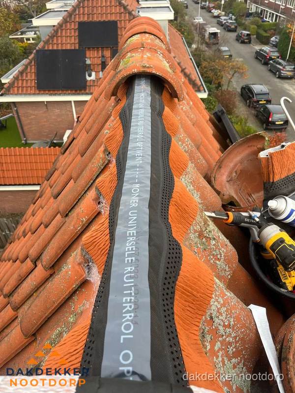 Dakdekker vervangt nokvorst met ruiterrol op pannendak in Nootdorp Dakdekker vervangt nokvorst met ruiterrol op pannendak in Nootdorp