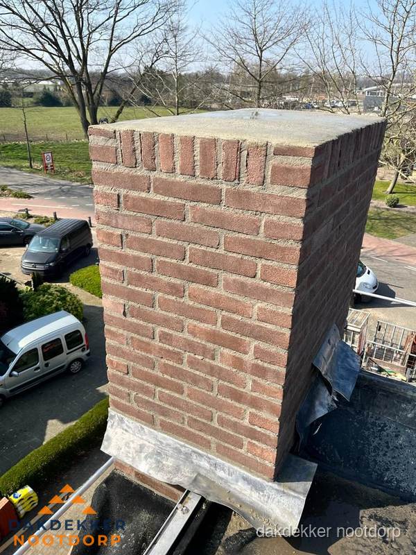 Gemetselde schoorsteen met loodaansluiting op dak in Nootdorp Gemetselde schoorsteen met loodaansluiting op dak in Nootdorp