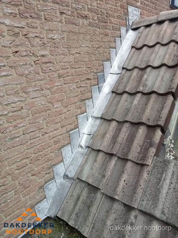 Loodslabben langs dakaansluiting bij bakstenen muur in Nootdorp