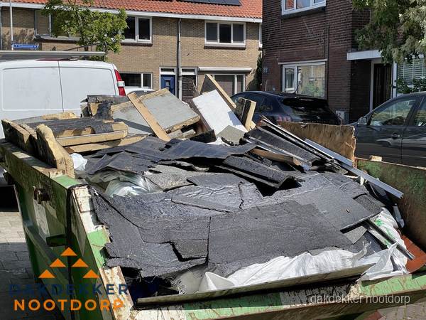 Afvalcontainer met gesloopt dakmateriaal tijdens dakkapel renovatie in Nootdorp Afvalcontainer met gesloopt dakmateriaal tijdens dakkapel renovatie in Nootdorp