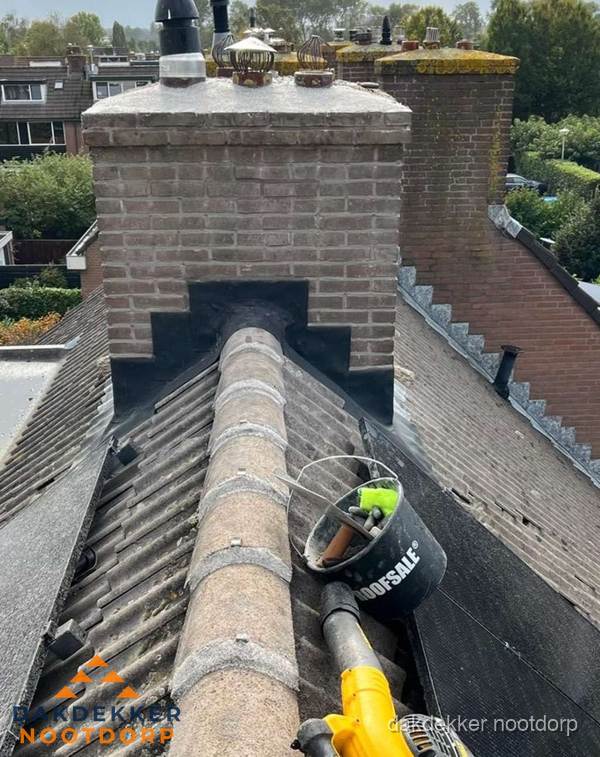 Schoorsteen met loodaansluiting en nokvorst op pannendak in Nootdorp Schoorsteen met loodaansluiting en nokvorst op pannendak in Nootdorp