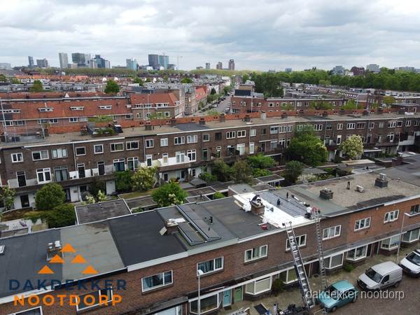Spoed dakdekker aan het werk op plat dak in woonwijk Nootdorp
