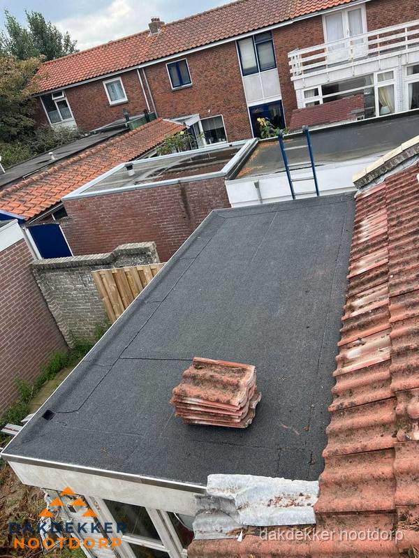 Plat dak aanbouw met bitumen naast schuin pannendak in Nootdorp Plat dak aanbouw met bitumen naast schuin pannendak in Nootdorp