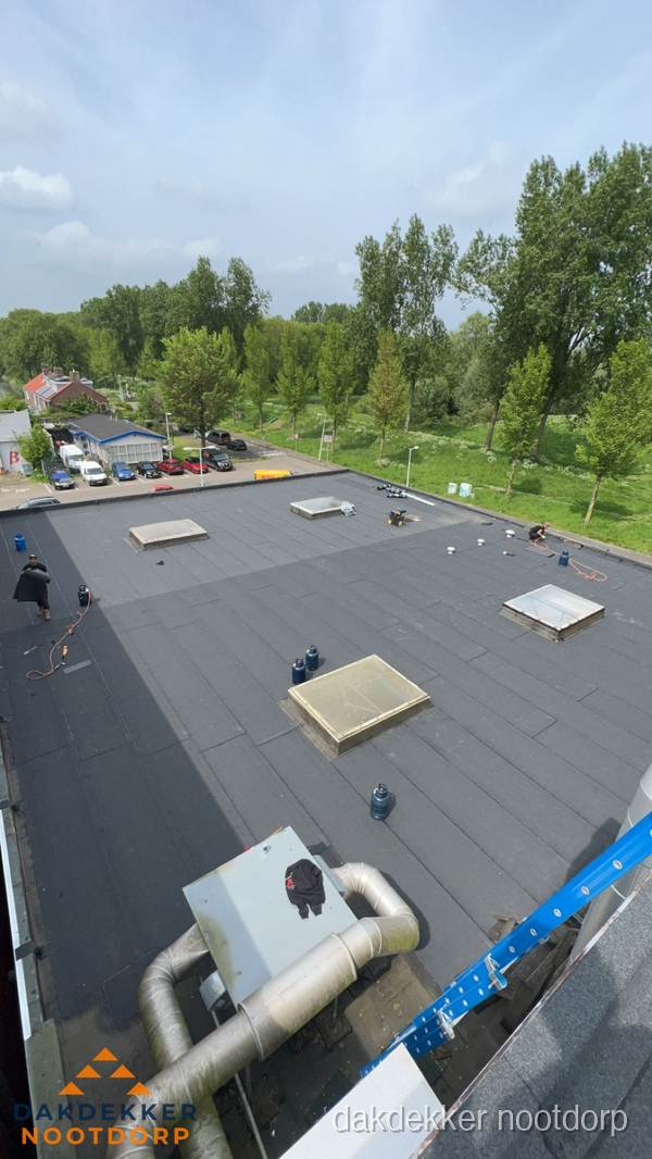 Dakdekker aan het werk op groot plat dak met bitumen in Nootdorp Dakdekker aan het werk op groot plat dak met bitumen in Nootdorp