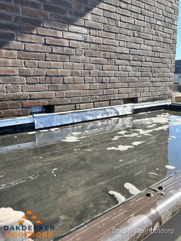 Stilstaand water op plat dak door slechte afwatering in Nootdorp Stilstaand water op plat dak door slechte afwatering in Nootdorp