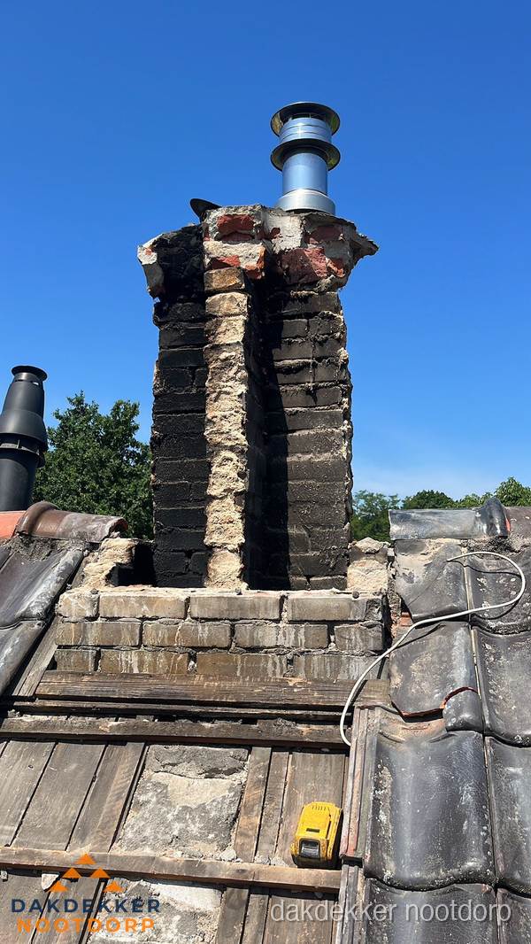 Beschadigde schoorsteen met nieuwe rookgasafvoer op oud dak in Nootdorp Beschadigde schoorsteen met nieuwe rookgasafvoer op oud dak in Nootdorp