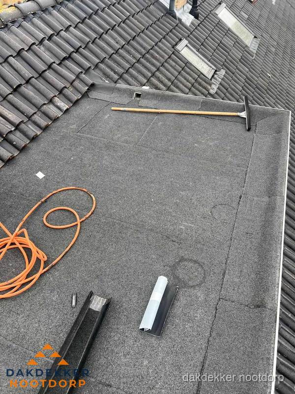 Plat dak reparatie met gereedschap en loodstroken in Nootdorp Plat dak reparatie met gereedschap en loodstroken in Nootdorp