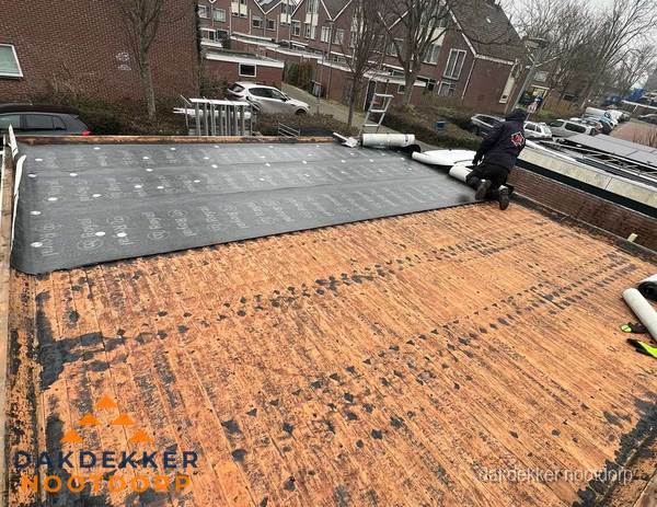 Dakdekker legt onderlaag op plat dak met houten constructie in Nootdorp Dakdekker legt onderlaag op plat dak met houten constructie in Nootdorp