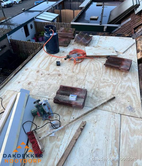 Dakreparatie werkzaamheden op plat dak met gereedschap in Nootdorp Dakreparatie werkzaamheden op plat dak met gereedschap in Nootdorp