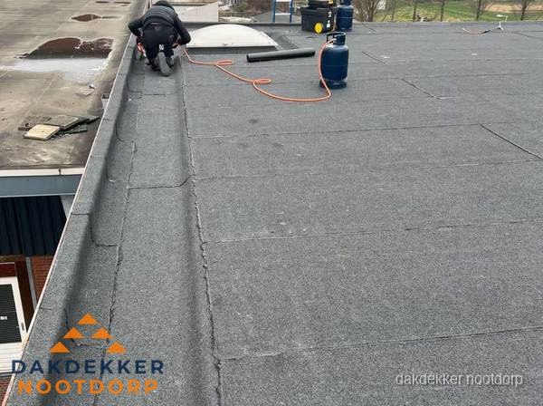Dakdekker repareert bitumen dakbedekking op groot plat dak in Nootdorp Dakdekker repareert bitumen dakbedekking op groot plat dak in Nootdorp